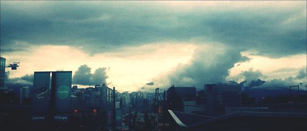 Buildings in city against cloudy sky