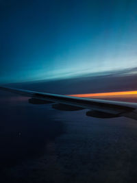 Airplane flying in sky at sunset