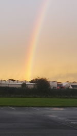 Scenic view of rainbow over field against sky