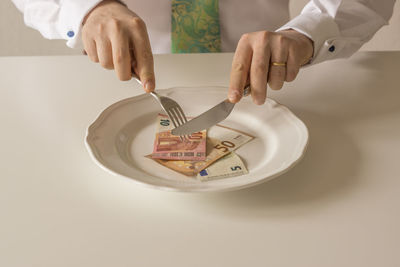 Close-up of hand holding eyeglasses on table