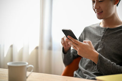 Midsection of woman using mobile phone