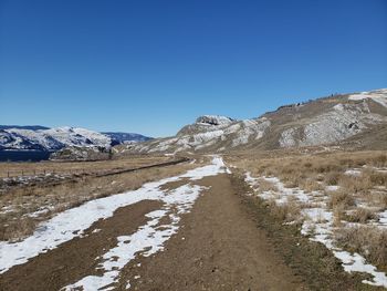 Scenic view of snowcapped mountains against clear blue sky