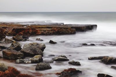 Aerial view of rocks on beach against sky