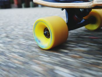 Cropped image of skateboard moving on street