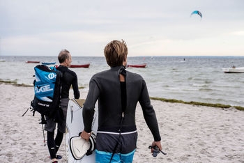 REAR VIEW OF PEOPLE ON BEACH