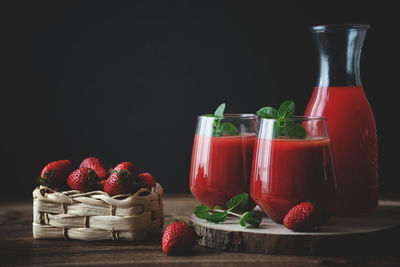 Various fruits in glass container against black background