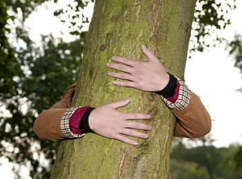 Woman embracing tree trunk in park