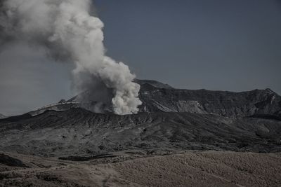 Smoke emitting from volcanic mountain against sky