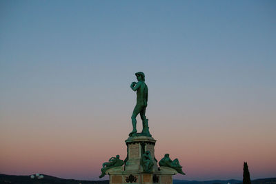 Low angle view of statue against sky during sunset