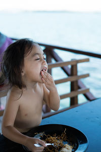 Cute girl eating food on table