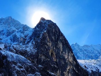 Scenic view of snowcapped mountains against blue sky