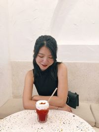 Young woman looking away while sitting on wall