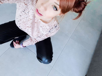 High angle portrait of woman on tiled floor