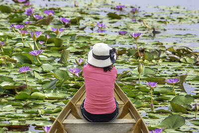 Rear view of woman with pink lotus water lily
