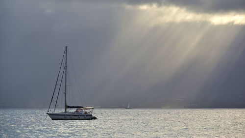 Sailboat sailing on sea against sky