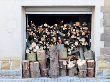 Stack of logs against stone wall