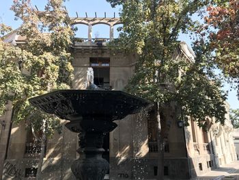 Low angle view of fountain against building in city