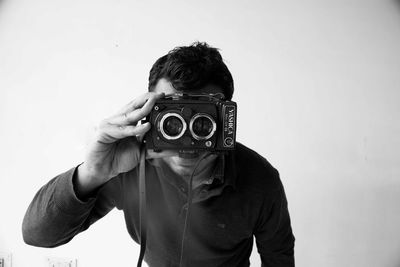 Midsection of woman photographing against white background