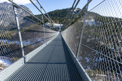 Empty footbridge against clear sky