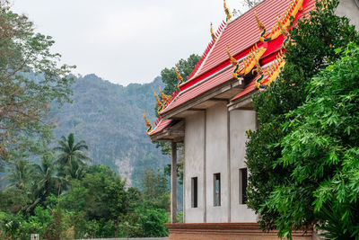 Traditional building by trees against sky