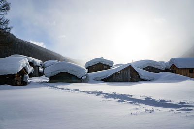 Snow covered village against sky