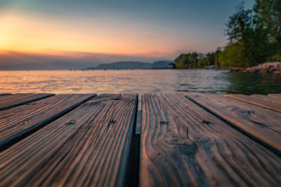 Pier over lake against sky during sunset