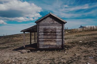 Abandoned house on field against sky