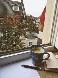 Close-up of coffee cup on window sill
