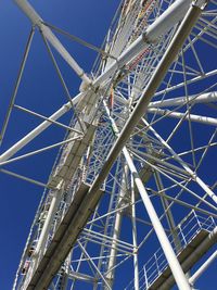 Low angle view of ferris wheel against blue sky