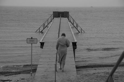 Rear view of woman walking on pier