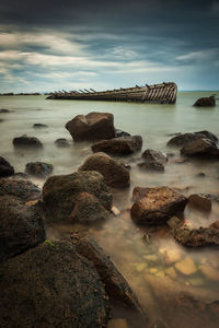 Rocks in sea against sky