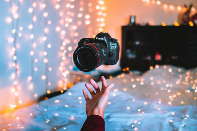 Midsection of woman photographing illuminated light