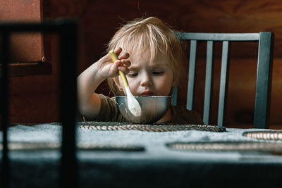 Portrait of cute boy sitting on table