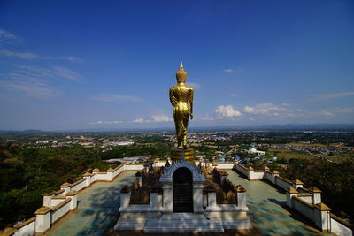 Statue in city against sky