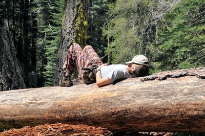 Man lying on rock in forest