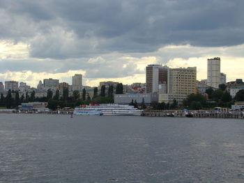 City buildings by sea against sky