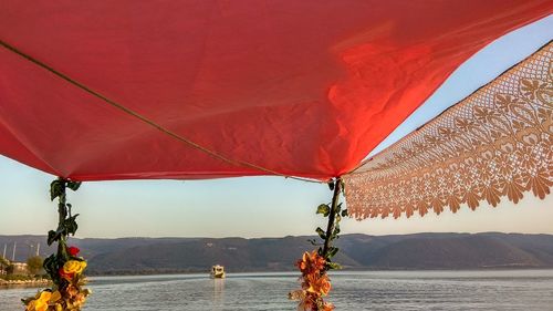 Red umbrella on beach against sky