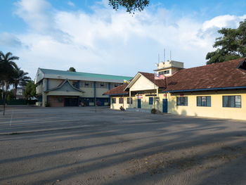 Houses by road amidst buildings against sky