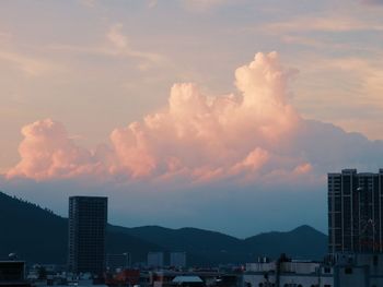 Buildings in city against sky during sunset