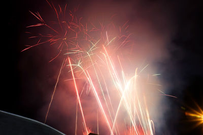 Low angle view of firework display at night