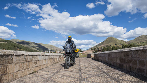 Motorbike driving over a bridge of the urubamba river, cusco, peru