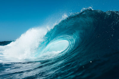 Blue wave breaking on the beach in summer