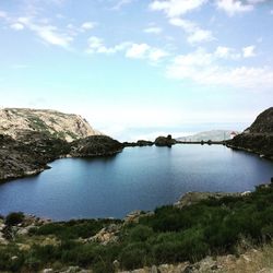 Scenic view of lake against cloudy sky