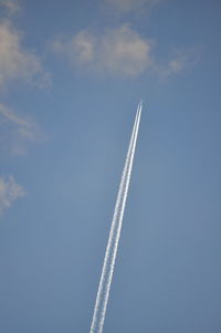 Low angle view of vapor trail against blue sky