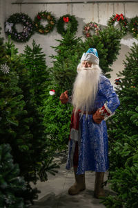 Rear view of woman standing by christmas tree