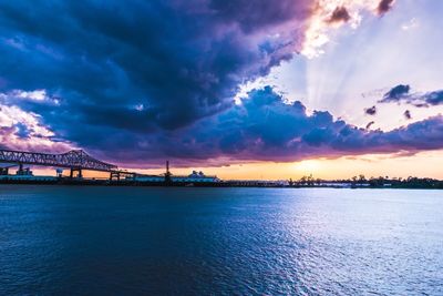 View of bridge over river against cloudy sky