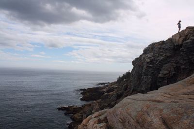 Scenic view of cliff by sea against sky