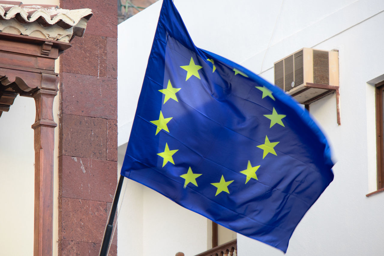 LOW ANGLE VIEW OF FLAG AGAINST BUILDINGS