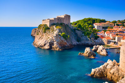 Panoramic view of buildings and sea against blue sky