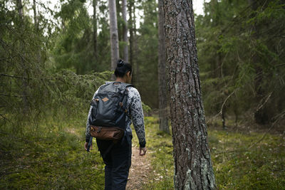 Rear view of man walking in forest